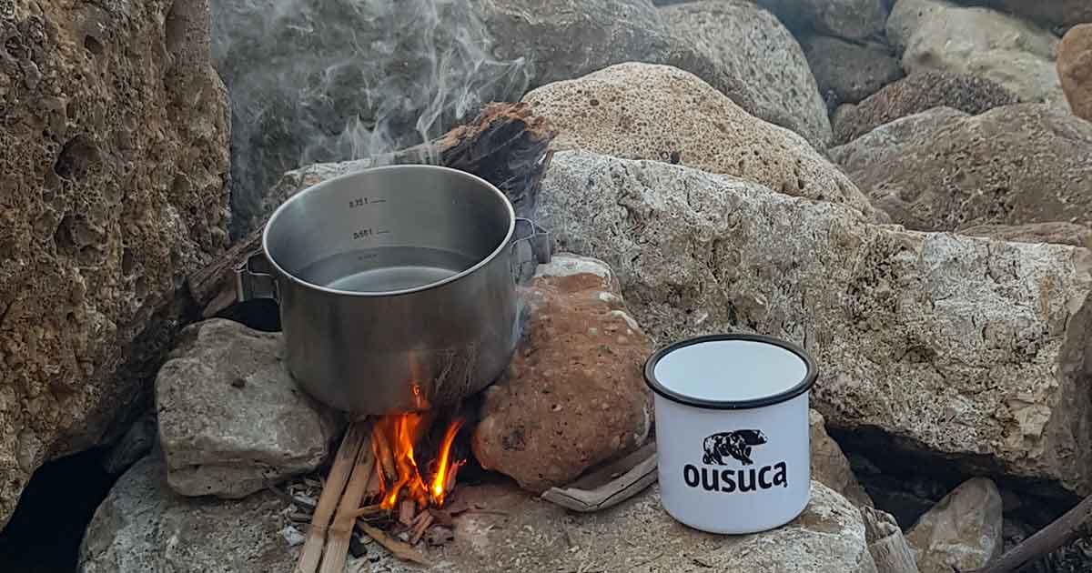 Emailletasse ousuca an Lagerfeuer