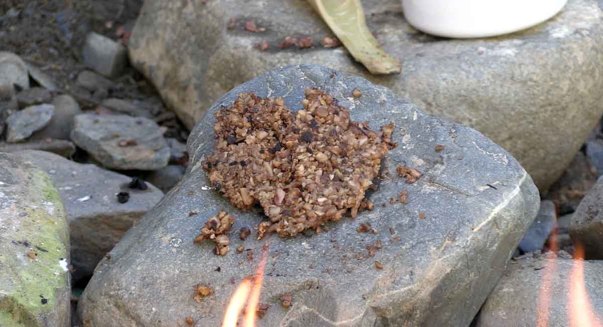 Backen von Eichelbrot auf einem heißen Stein am Lagerfeuer.