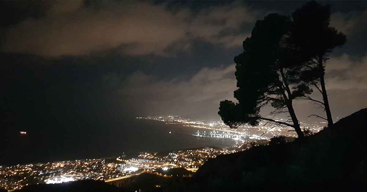 Blick nachts vom Gebirge auf Küste