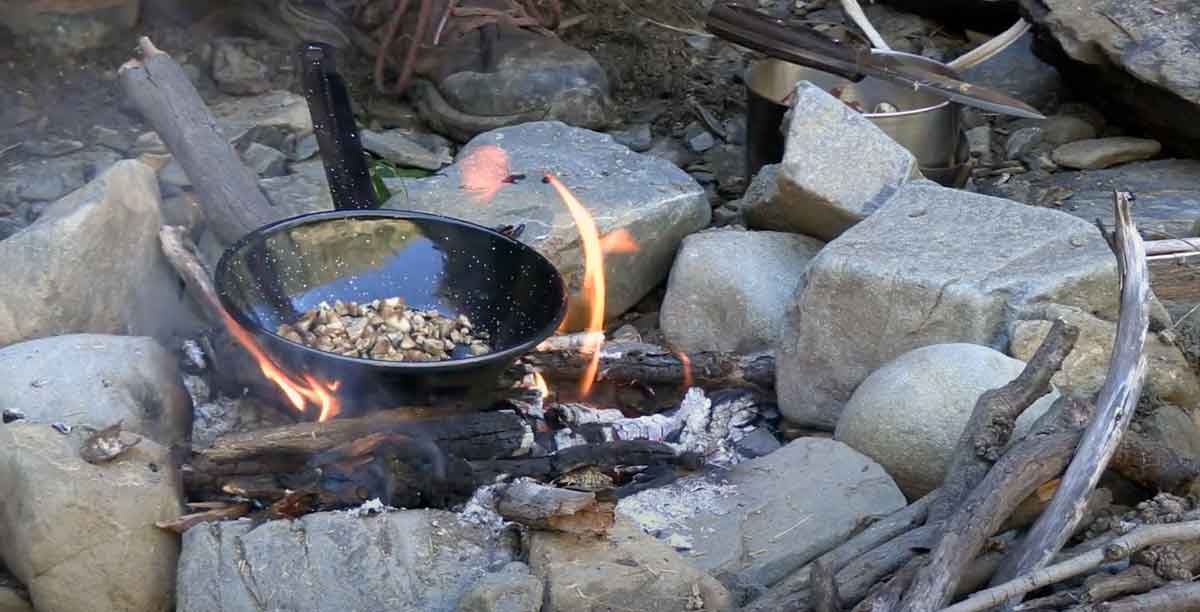 Essen zubereiten Outdoor über Feuer in der Pfanne
