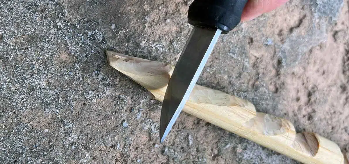 Holzstück für das Schnitzen von Kerben mit der Messerklinge markieren